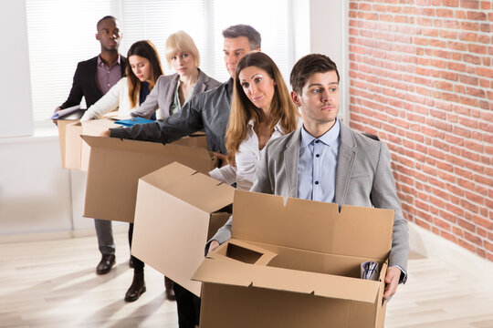 Row Of Businesspeople Standing With Cardboard Boxes