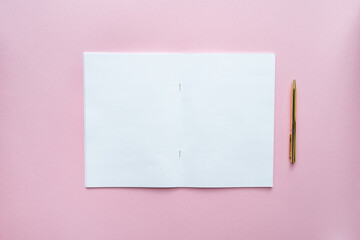 White empty notebook on pink background