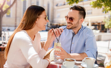 Romantic couple drinking coffee and lemonade, having a date in the cafe. Dating, love, relationships