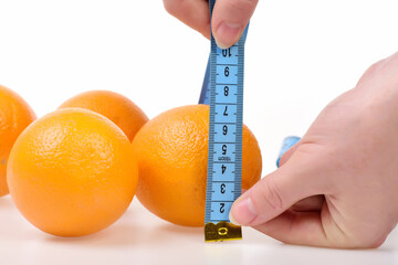 Fruit measured with blue flexible ruler in female hands