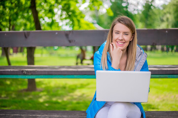 Pretty woman using laptop in park on a sunny day