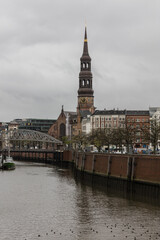 Fototapeta premium A view to the bell tower and the bridge on the canal Hamburg Germany Europe