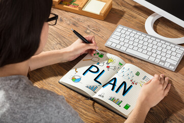 Businesswoman Drawing Plan Chart On Notebook