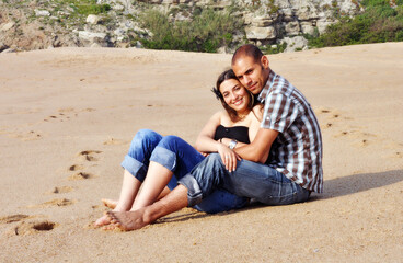 Fototapeta premium Young happy couple dating and teasing on the beach