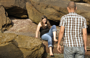 Young happy couple dating and teasing on the beach
