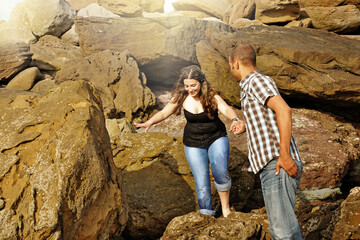 Young happy couple dating and teasing on the beach