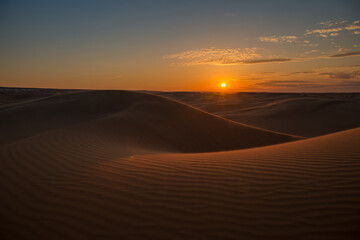 Naklejka na ściany i meble Beautiful sunset in sand dunes over barkhan desert in Kazakhstan