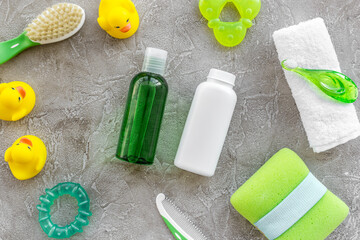 bath cosmetic set for kids, towel and toys on gray background top view pattern