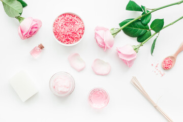 homemade spa with rose cosmetic set, cream, salt and oil on white background top view