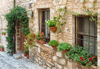 Fototapeta na wymiar Plants in pots on narrow streets of the ancient city of Spello, Umbria, Italy