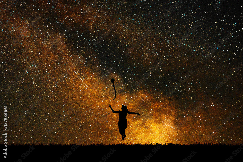 Wall mural silhouette joyful girl on a background of stars, the concept of joy and happiness.