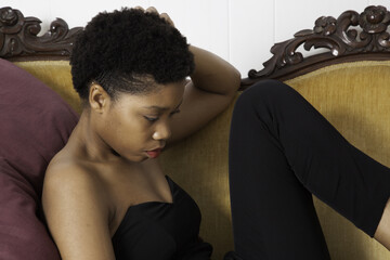 Black woman reclining and looking down
