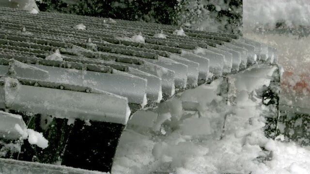 Snow groomer machine churning snow in slow motion