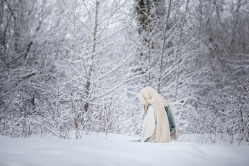 Jesus Christ kneeling and praying in the snow. 