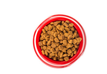 Red pet feeder. Bowl filled with dried food. Kibble on isolated white background