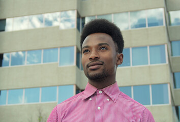 young businessman looking away office building pink shirt