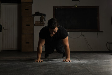 Naklejka premium Strong man doing push-ups in a gym
