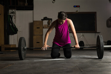 Woman adjusting her grip on a barbell