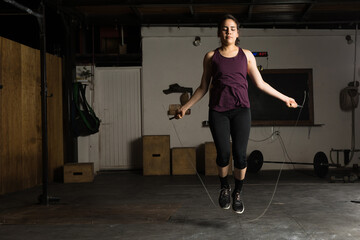 Fototapeta na wymiar Woman using a jump rope at the gym