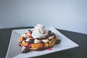 Waffles with whipped cream, banana and fruit jelly