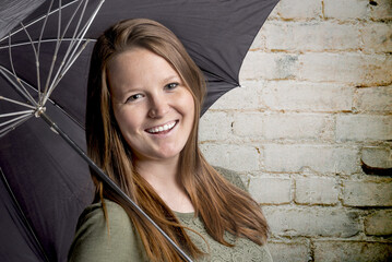 girl with umbrella and white brick background