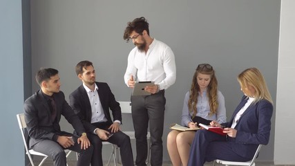 successful businessman show a presentation on the screen of the tablet PC. colleagues working in the lobby of an office building. business negotiations in an informal setting