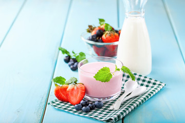 Strawberry yogurt and milk on a table. Selective focus. Copy space