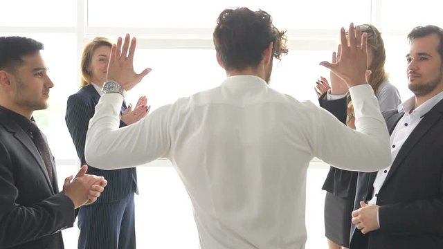 group of businessman's celebrating a success. the man give a high five to a colleague. slow motion