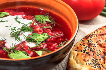 beet soup in a clay plate served on a rustic table
