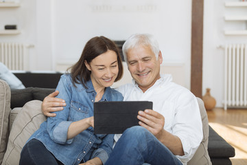 Mature couple at home websurfing with tablet