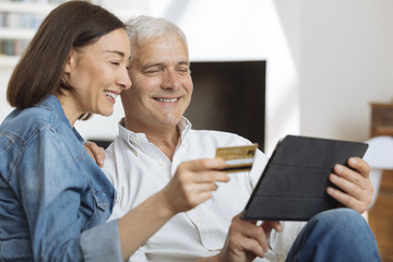 Mature couple using credit card to shop online