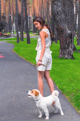 Woman walking in a park with white dog