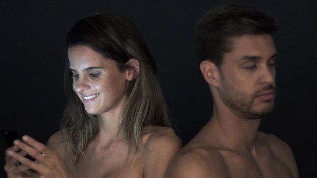 Woman using smartphone and ignoring boyfriend