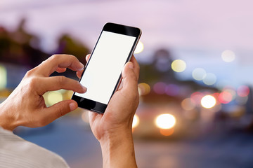 Man using mobile smartphone on Street night Background. Blank screen smartphone for graphic display montage.