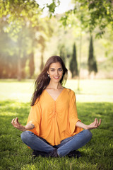 Fototapeta premium beautiful girl doing yoga exercises in a park