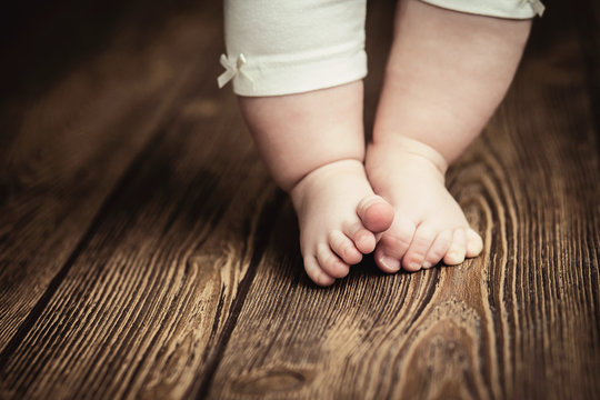 Baby feet doing the first steps. Baby's first steps. Baby feet .