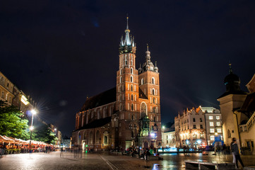 Evening illuminated Mary's Basilica with a square in the Polish city of Krakow
