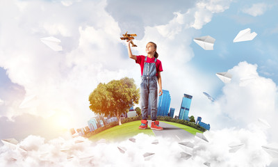 Concept of careless happy childhood with girl dreaming to become pilot