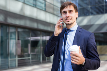 Cheerful male standing outdoor and talking phone