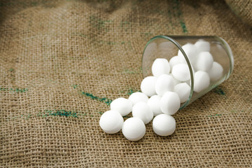 Moth balls in the glass over the sackcloth