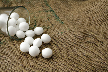 Moth balls in the glass over the sackcloth