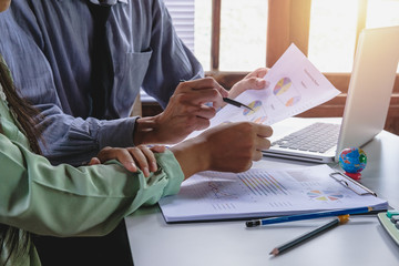 Business adviser analyzing financial figures denoting the progress in the work of the company.Close...