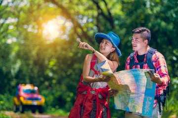 Asian couple for a new adventure looking for the right way on the map, they lost and miss way and observing a map to find the the right way.