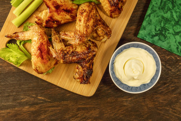 Chicken wings with celery sticks, white sauce, and copyspace
