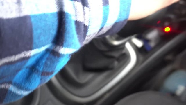 switching manual gearbox, the man's hand shifts gears in the car.