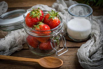 Strawberry in jar on wooden background.