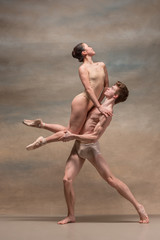 Obraz premium Couple of ballet dancers posing over gray background