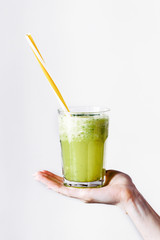 Woman holds a glass with green cocktail