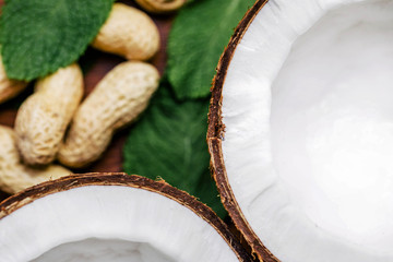Peanuts and coconut lie on green leaves