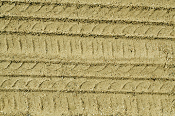 Car tires tracks on sandy road.